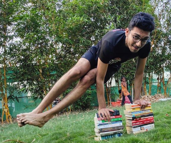 Manthan Shah (BBA’18) utilising books in a Yoga challenge<